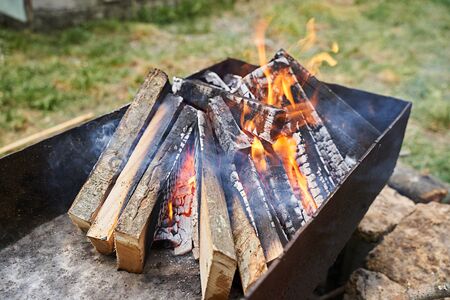 firewood is burning in the grill before roasting meat for the holidays.の写真素材