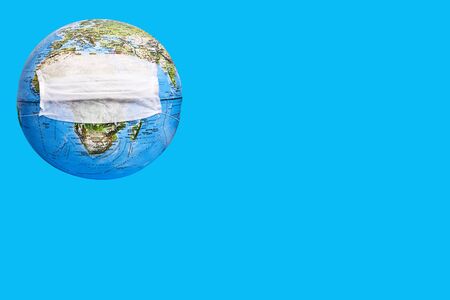 globe in a medical mask on a blue background. planet Earth is in dangerの写真素材