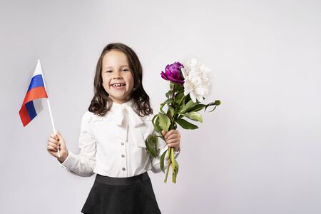 a beautiful girl holds a flag in one hand, flowers in the otherの写真素材