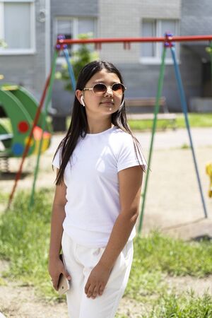 beautiful Asian girl in glasses with phone on the street.の写真素材