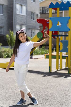 beautiful Asian girl with phone on the streetの写真素材