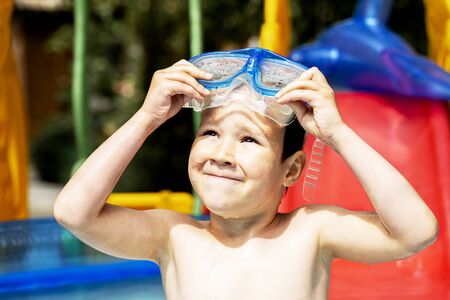 Happy laughing toddler boy having fun in a swimming pool.の写真素材