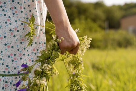 hand close up holding a wreath of flowers.の写真素材