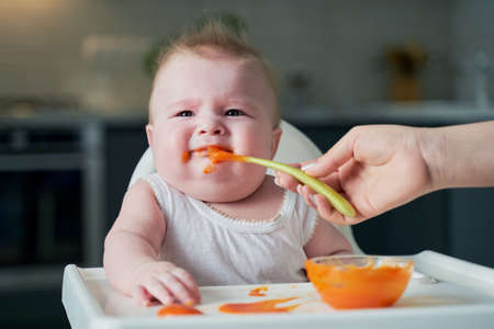 a little boy doesn't want to eat pumpkin puree. the first solid foods at 6 monthsの写真素材