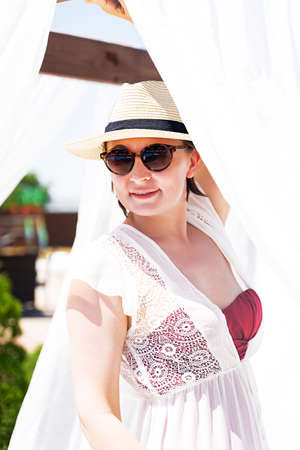 a beautiful young girl in a hat is lying on the beachの写真素材