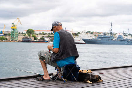 fisherman fishing in the Bay against the background of ships.の写真素材