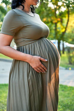 pregnant girl close up against the sunset lightの写真素材