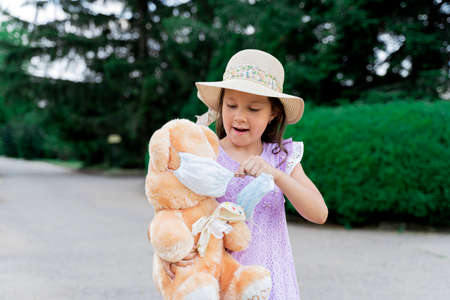 a girl and a toy in a mask. remove the mask. end of isolation. end of the epidemic.の写真素材