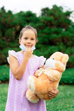 a little girl takes off her medical mask . the pandemic is over.の写真素材