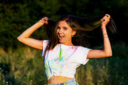 a young funny girl smeared with paint smiles.の写真素材