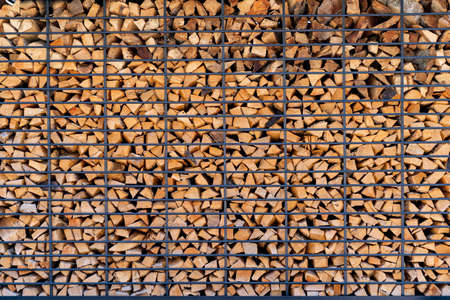 Close up of neatly stacked pile of fire wood good for background texture or wall paper screen saver. Natural wood productの写真素材