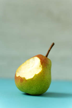 Bitten pear and one full. Isolated on white backgroundの写真素材