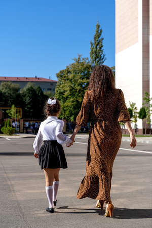 mom takes her daughter to first grade schoolの写真素材