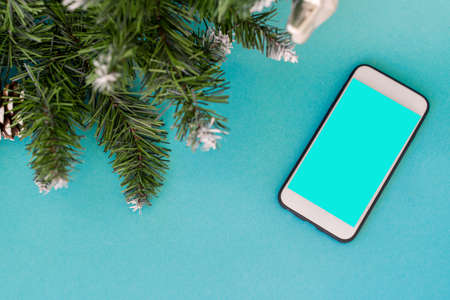 phone on a background with a Christmas tree and decoration on a concrete background.の写真素材