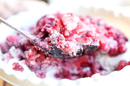 fresh juicy ripe raspberries mixed with sugarの写真素材