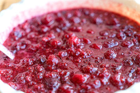 mixed with sugar fresh juicy ripe raspberries should give juice before pouring into cansの写真素材