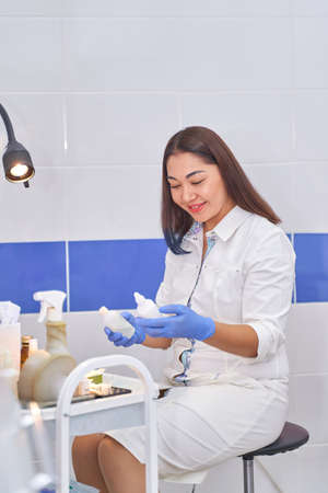 Asian woman gynecologist doctor in white coat looks into the frame.の写真素材