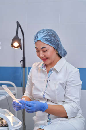 Asian Woman doctor in white coat takes tests.の写真素材