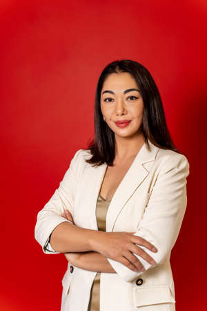 beautiful business Asian girl in white jacket on red backgroundの写真素材