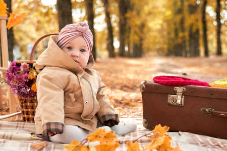a small child is sitting in an autumn Park in a beautiful turban.の写真素材
