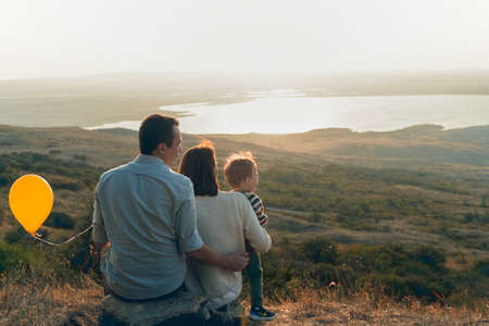 Beautiful young family with a small child on an autumn walkの写真素材