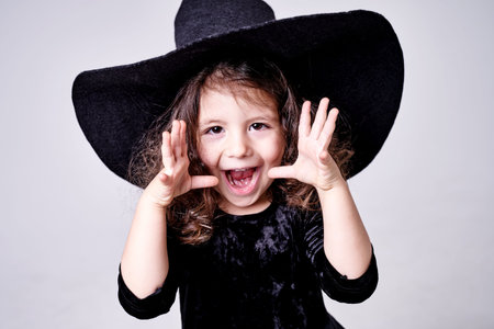 funny witch girl in a hat scares people