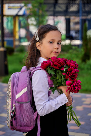 little beautiful schoolgirl in a white shirt with flowersの写真素材