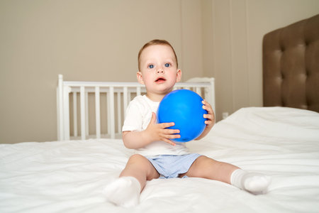 a small child with blue eyes holds a ballの写真素材