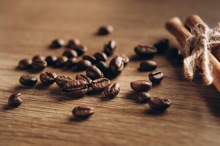 Coffee beans along with cinnamon on the table view from above, fragrant coffee comes steamの写真素材