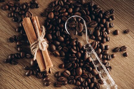 Coffee beans along with cinnamon on the table view from above, fragrant coffee comes steamの写真素材
