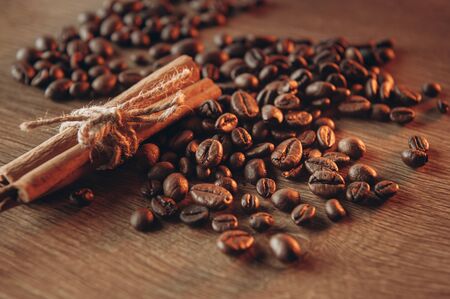 Coffee beans along with cinnamon on the table view from above, fragrant coffee comes steamの写真素材