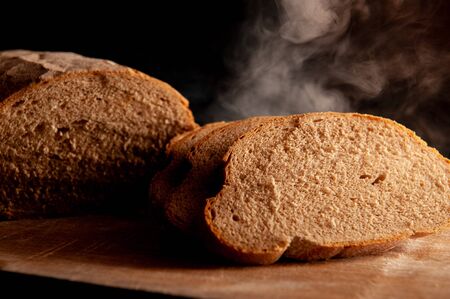 baked bread cut into pieces on a black background. Hot breadの写真素材