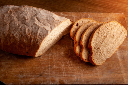 baked bread cut into pieces on the wooden board