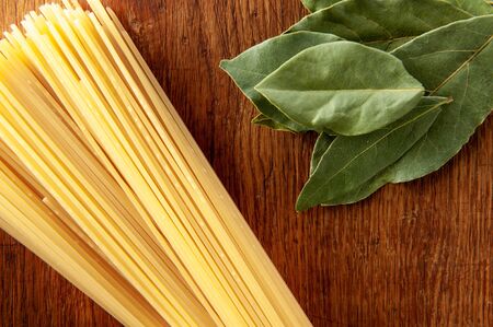 pasta with bay leaf and spices on a wooden table, food close-upの写真素材