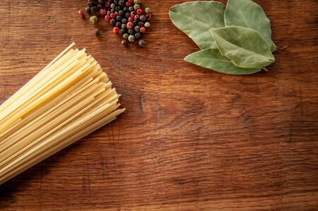 pasta with bay leaf and spices on a wooden table, food close-upの写真素材