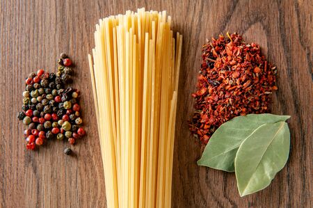 pasta with bay leaf and spices on a wooden table, food close-upの写真素材