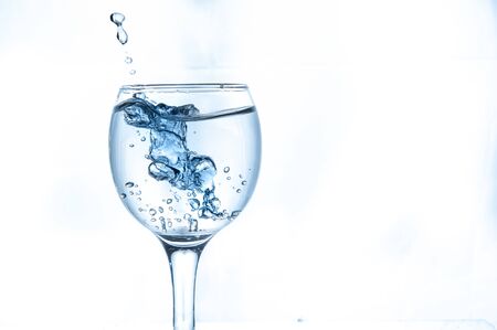 water splashing from glass isolated on white backgroundの写真素材