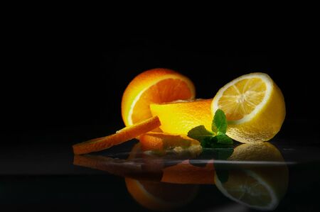 Fruits mint, orange and lemon on black backgroundの写真素材