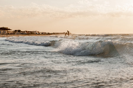 sunset on the sea in the background people bathe and rejoice, rest at sea
