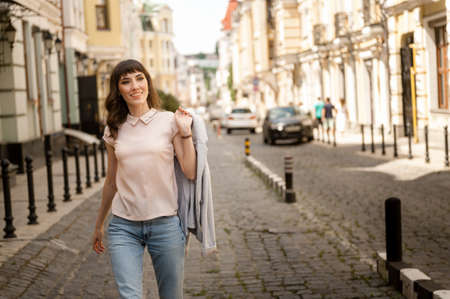Girl walks around the city in the hands of a jacket drillの写真素材