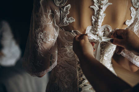 The brides back in the wedding dress. Bride tied bow on the back of a wedding dressの写真素材