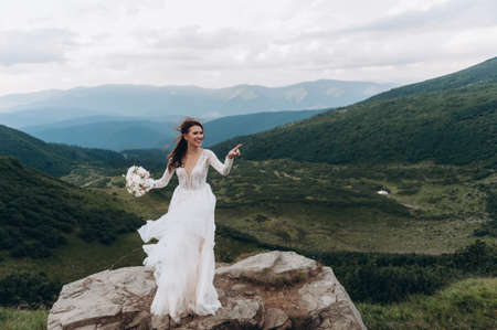 the bride is preparing to throw the bouquet. Bride in the mountainsの写真素材
