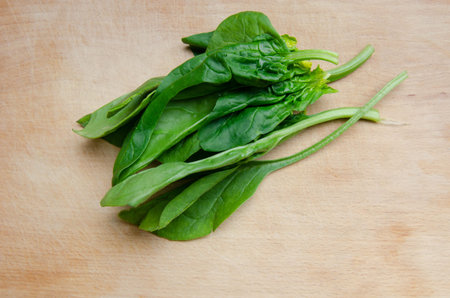 Spinach leaves on a wooden board. Free text space