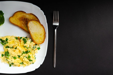 omelet with spinach and croutons on a white plate. On a gray background with free space for text. View from above.の写真素材