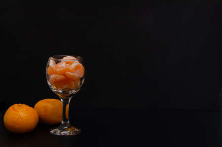 ripe tangerine and on a black background with a place for inscriptionの写真素材