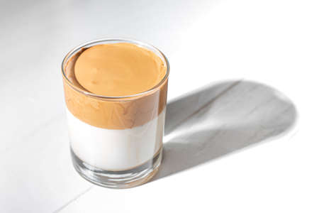 dalgon coffee on a light background. Dalgon dalgon coffee is a cold drink with milk and instant coffee that is whipped into a foam. this drink is extremely popular all over the worldの写真素材