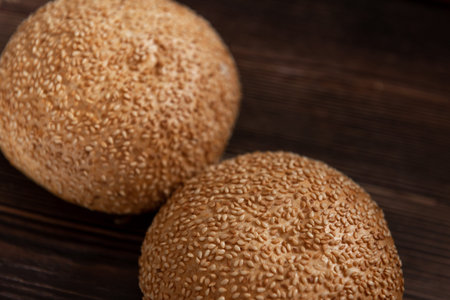 a bun with sesame on a wooden board. close up.