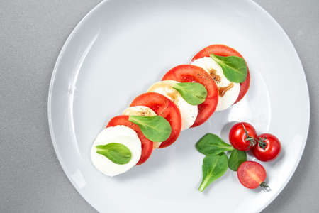 Italian Cuisine. Traditional Italian cuisine Caprese salad on a gray plate on a gray background.の写真素材