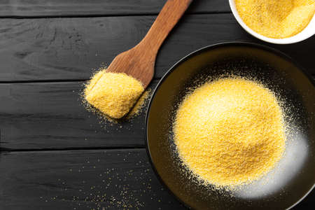 Heap of Polenta or Cornmeal Flour in a white bowl. Ground Dried Corn or Corn Grits. Top View, Copy Space. Healthy Grains Concept.の写真素材