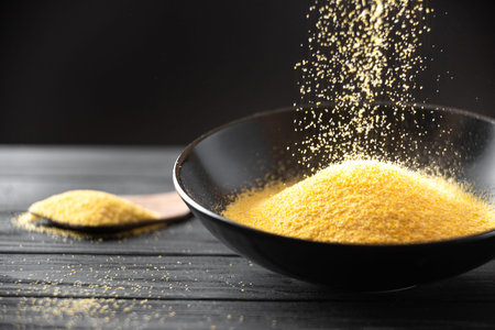 The dry porridge polenta is poured into the plate of porridge. The process of pouring dry polenta...